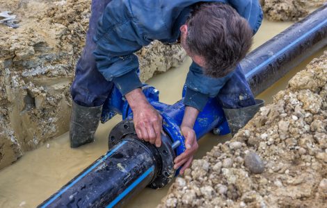 BELGRADE, SERBIA - DECEMBER 23: Close up of installing water pipe valve in a trench. Laying a water pipeline, working on water valves. Selective focus. At construction site in December 2014.